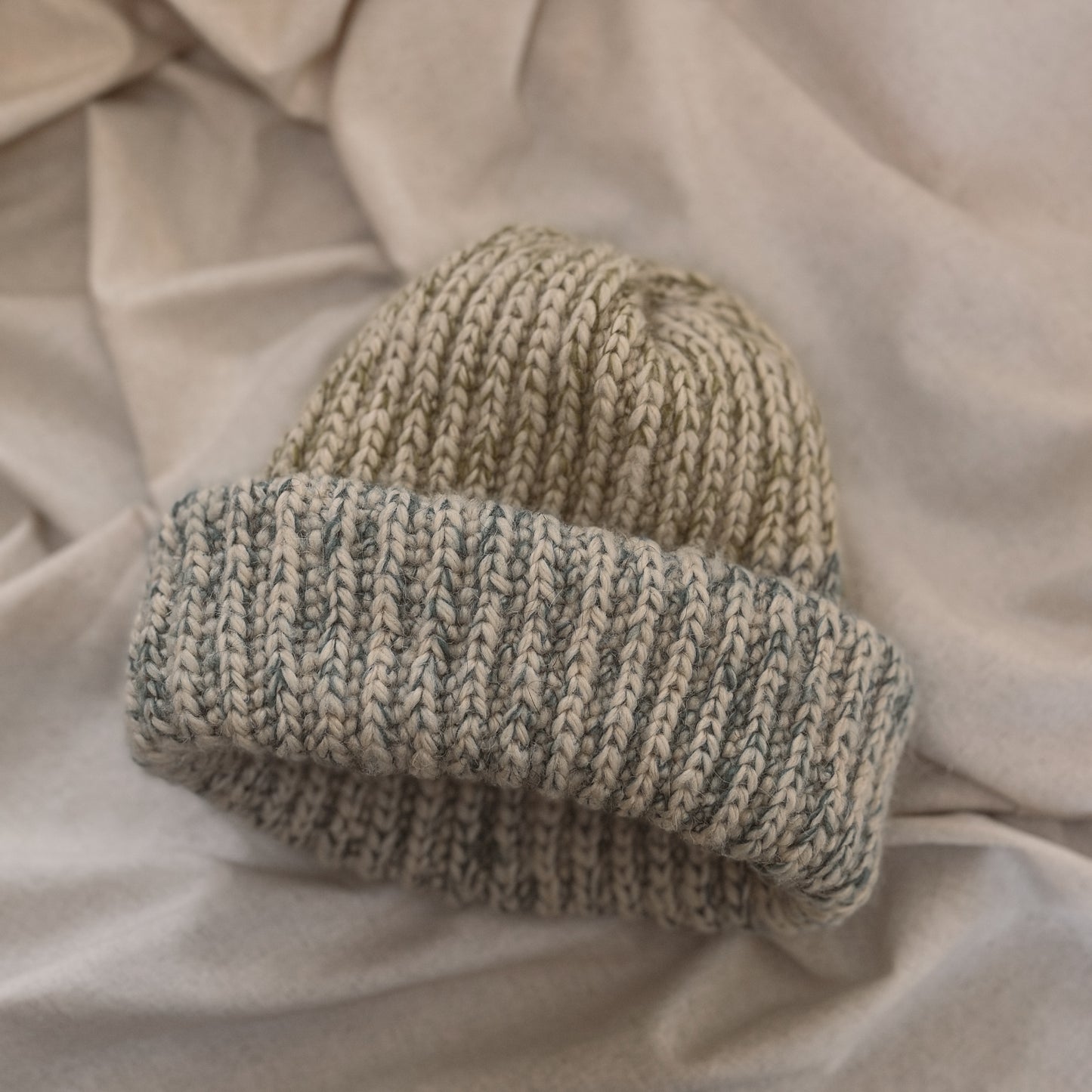 A ribbed crochet beanie hat in shades of green and blue to represent Biscayne national park made with mohair and alpaca yarn