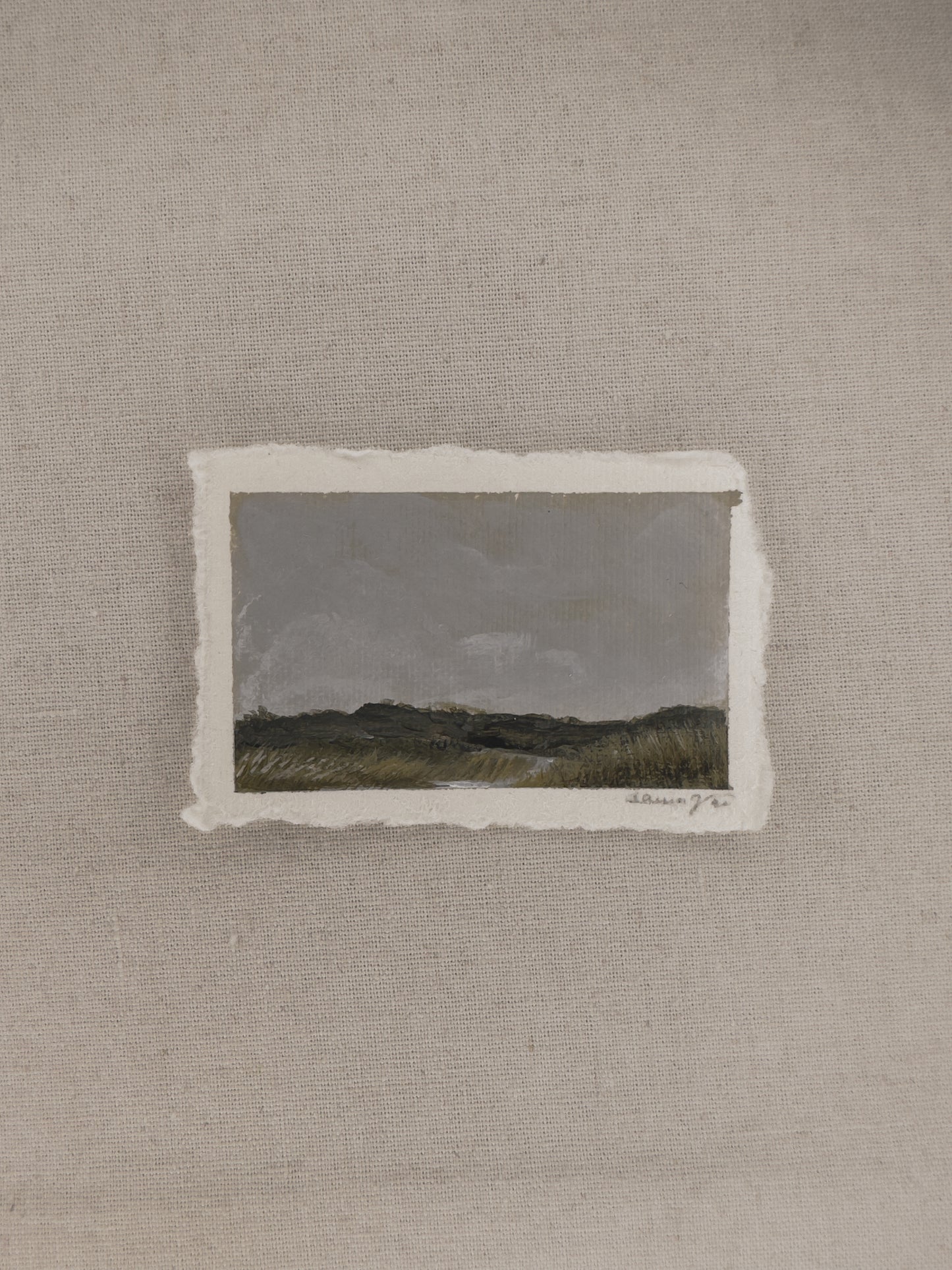 A miniature landscape painting with a cloudy sky and river part of The Journey Collection by Laura Van Moorleghem