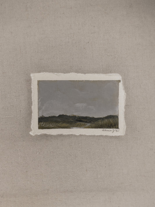 A miniature landscape painting with a cloudy sky and river part of The Journey Collection by Laura Van Moorleghem