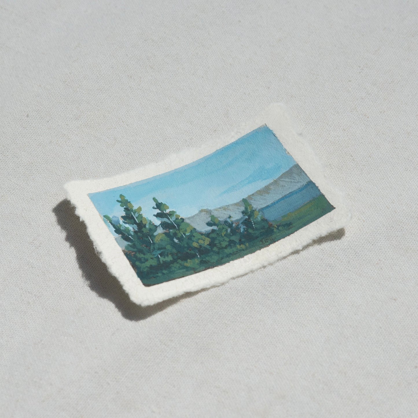 Side profile of pine trees overlooking crater lake in Crater Lake National Park painting on deckled edge 100% cotton rag paper