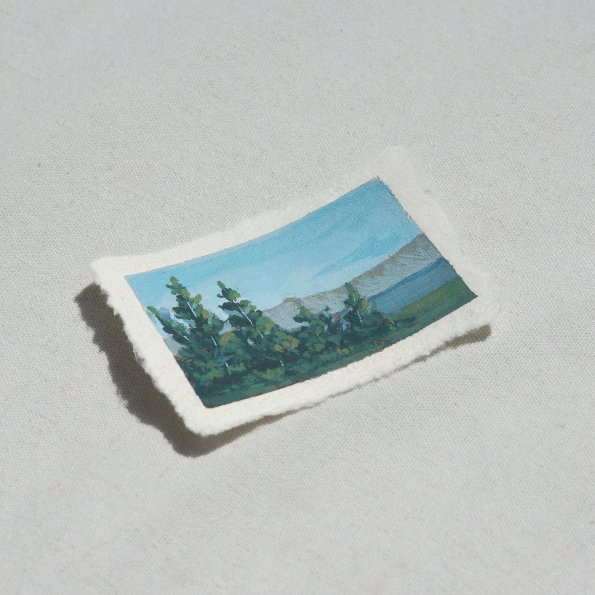 Side profile of pine trees overlooking crater lake in Crater Lake National Park painting on deckled edge 100% cotton rag paper