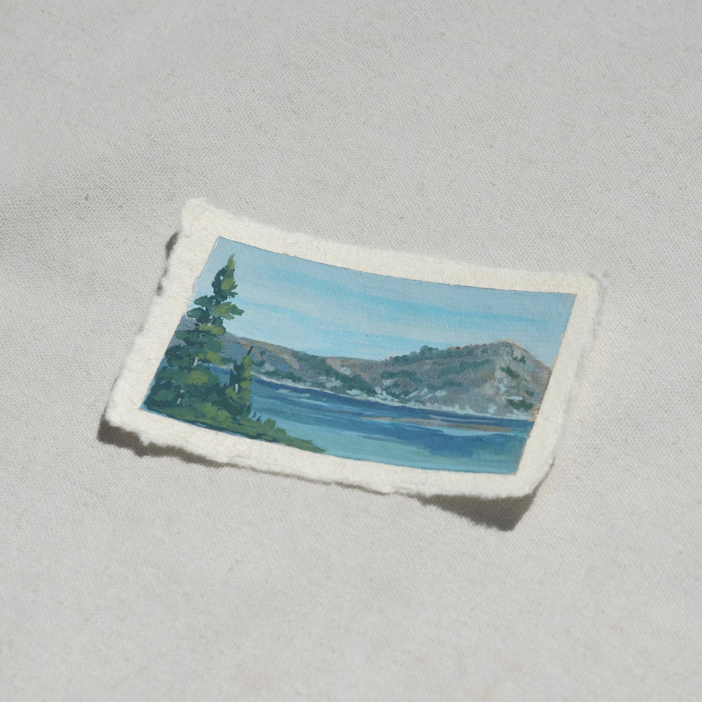 Side profile of crater lake mountains and pine tree overlooking Crater Lake at Crater Lake National Park painting on deckled edge 100% cotton rag paper