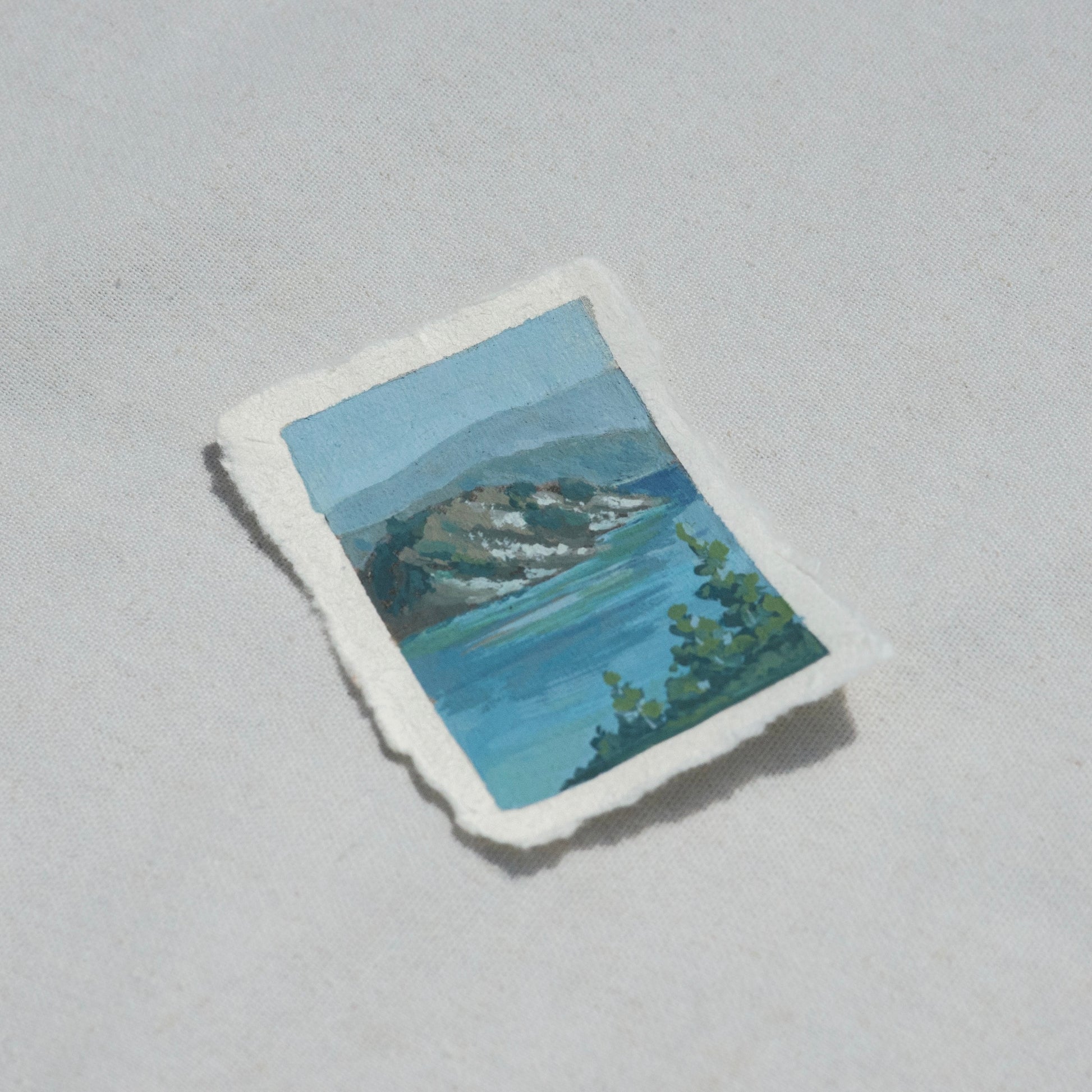 Side profile of wizard island in the blue waters of Crater lake in Crater Lake National Park painting on deckled edge 100% cotton rag paper