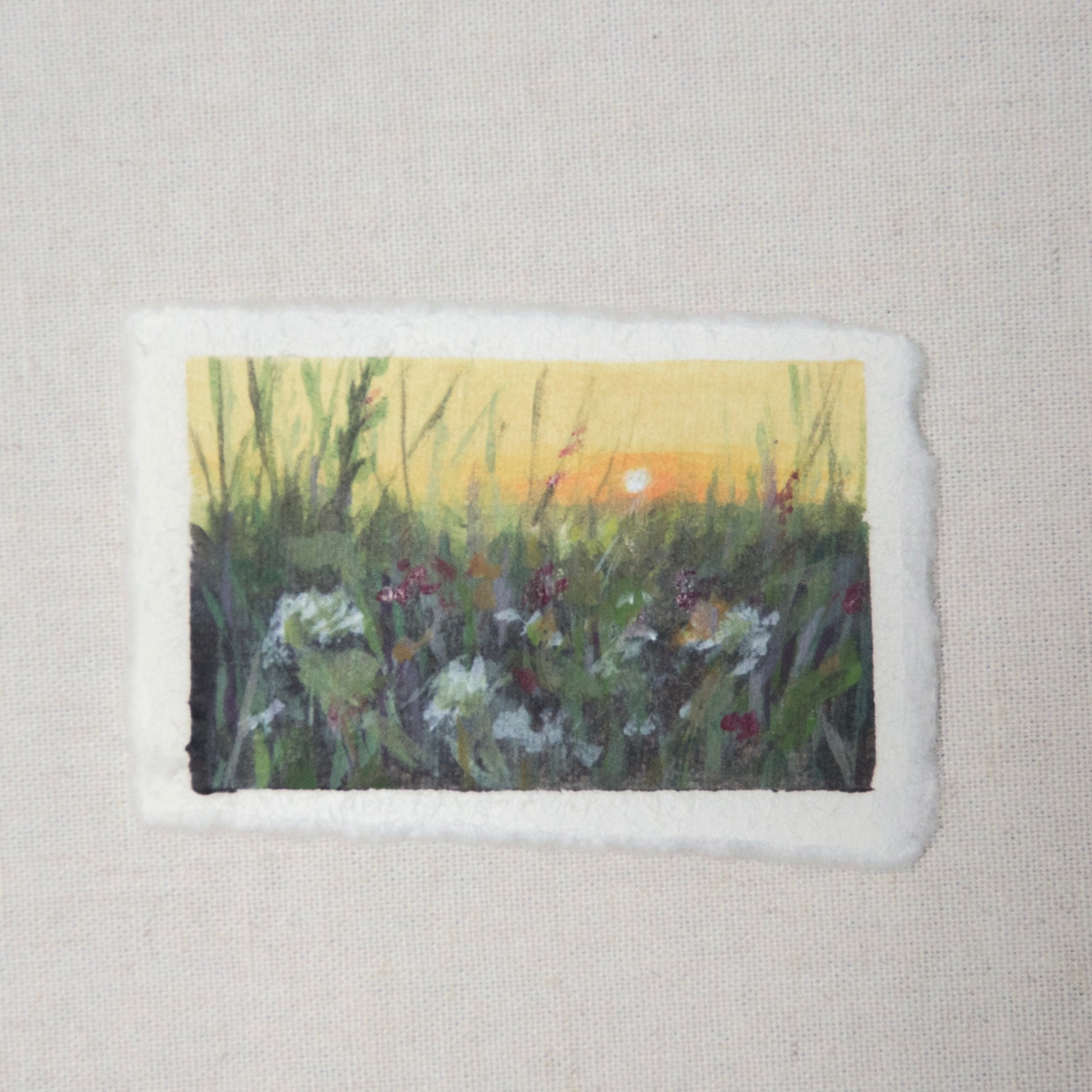 A small painting depicting a floral field with a deckled edge on 100% cotton rag paper by Laura van Moorleghem