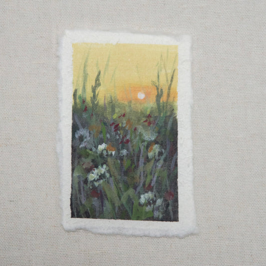 A small painting featuring a sunset over a field of flowers, painted with gouache and acrylic on cotton rag paper with a deckled edge by artist Laura van Moorleghem