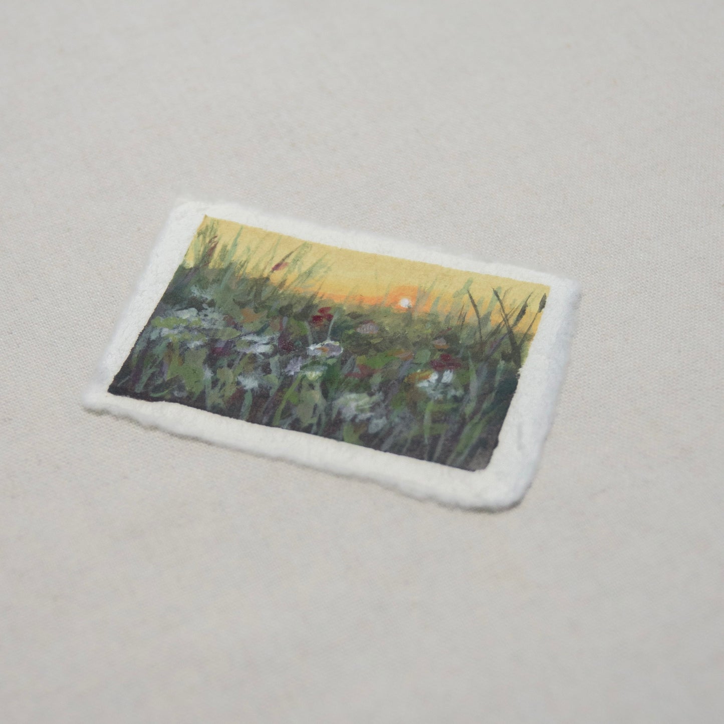 Side profile of a flower field painting on deckled edge 100% cotton rag paper