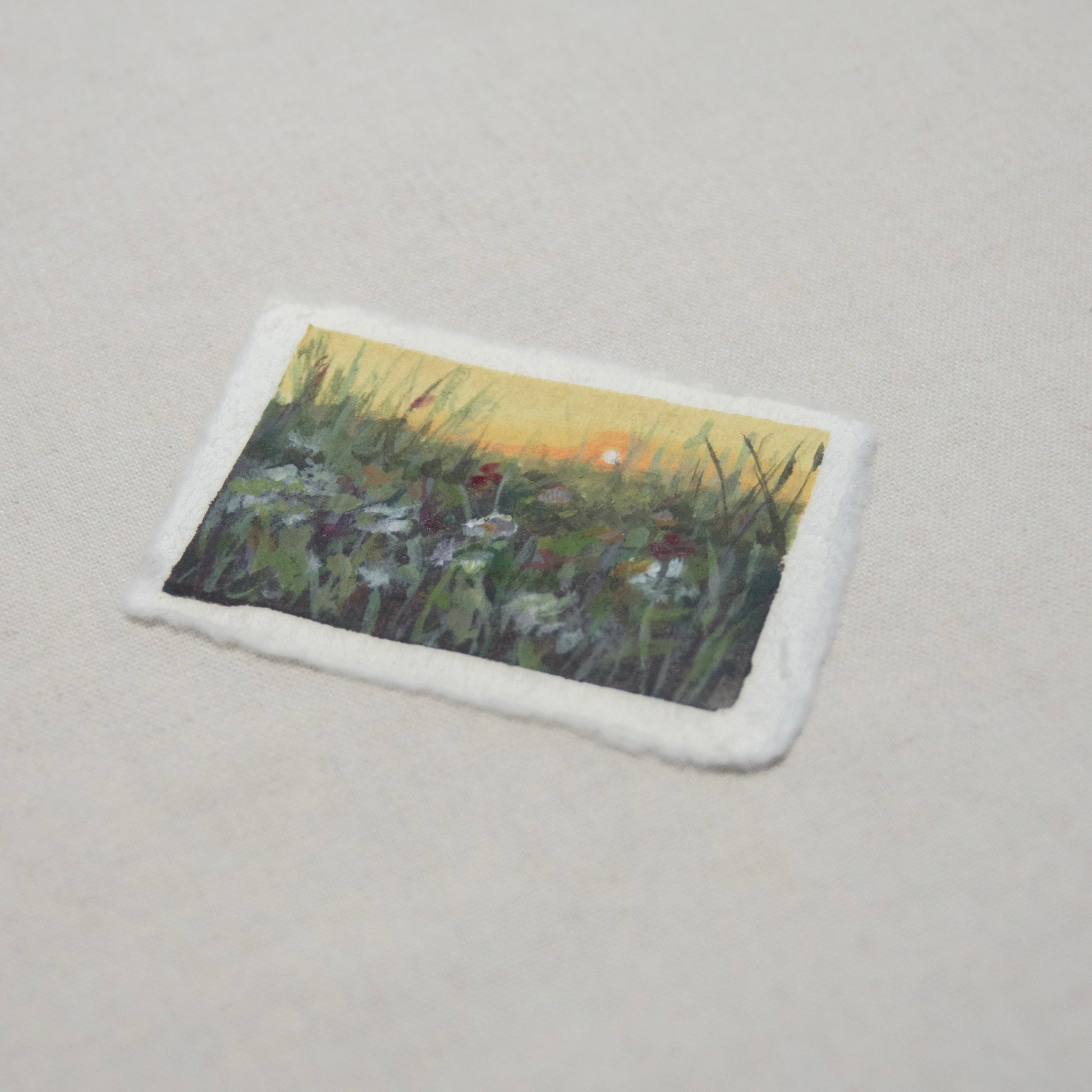 Side profile of a flower field painting on deckled edge 100% cotton rag paper