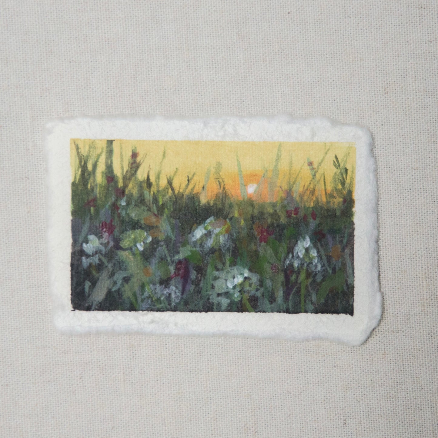 A small painting depicting a floral scene at sunset with a deckled edge on 100% cotton rag paper by Laura van Moorleghem 