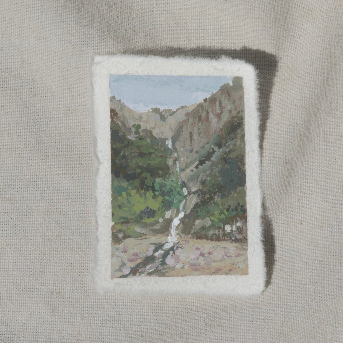 A miniature painting depicting a waterfall and a valley in Kings Canyon National Park, executed in gouache on cotton rag paper with a deckled edge.