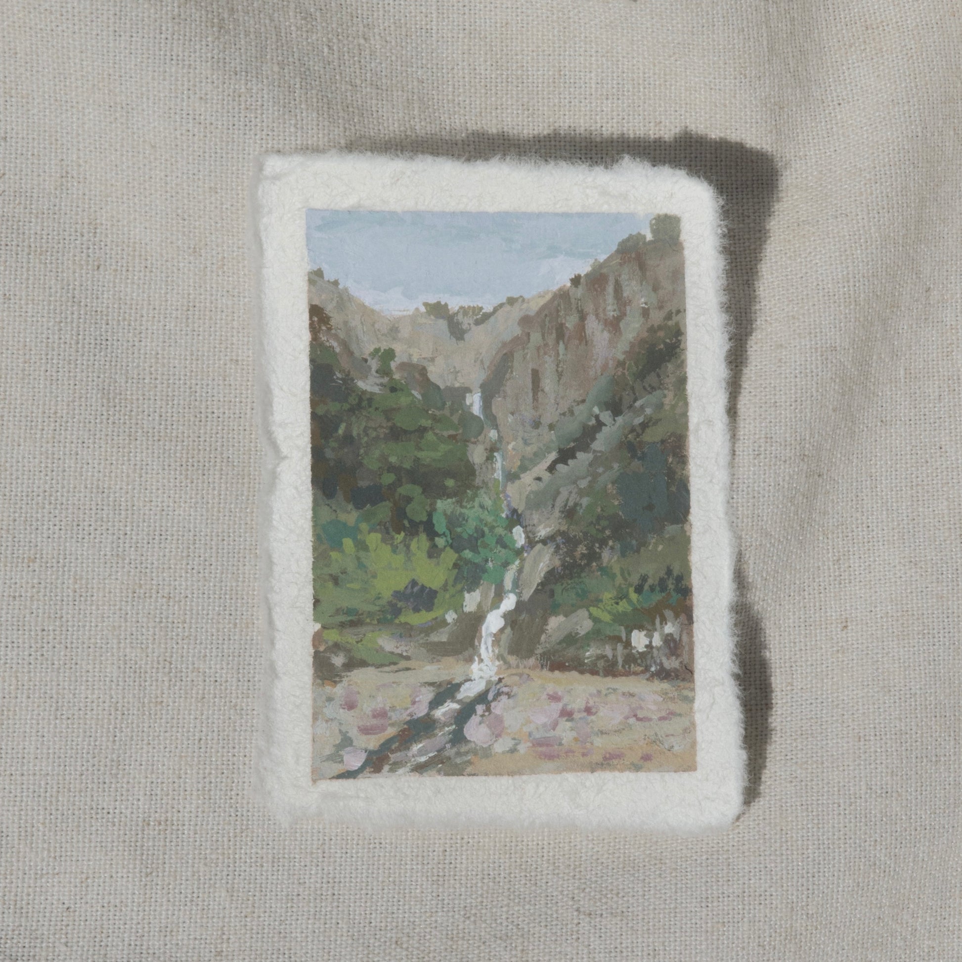 A miniature painting depicting a waterfall and a valley in Kings Canyon National Park, executed in gouache on cotton rag paper with a deckled edge.