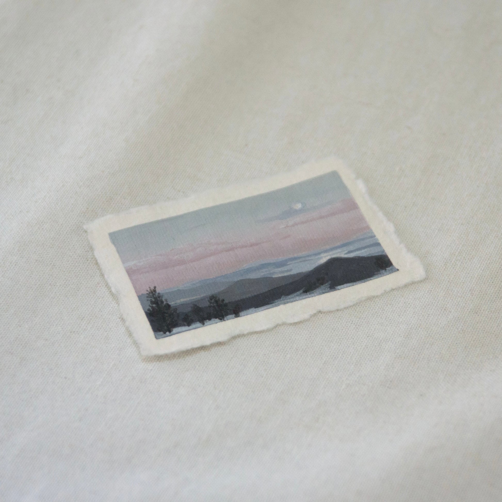 Side profile of overlook at Lassen Volcanic National Park of lakes and mountains during sunset painting on deckled edge 100% cotton rag paper