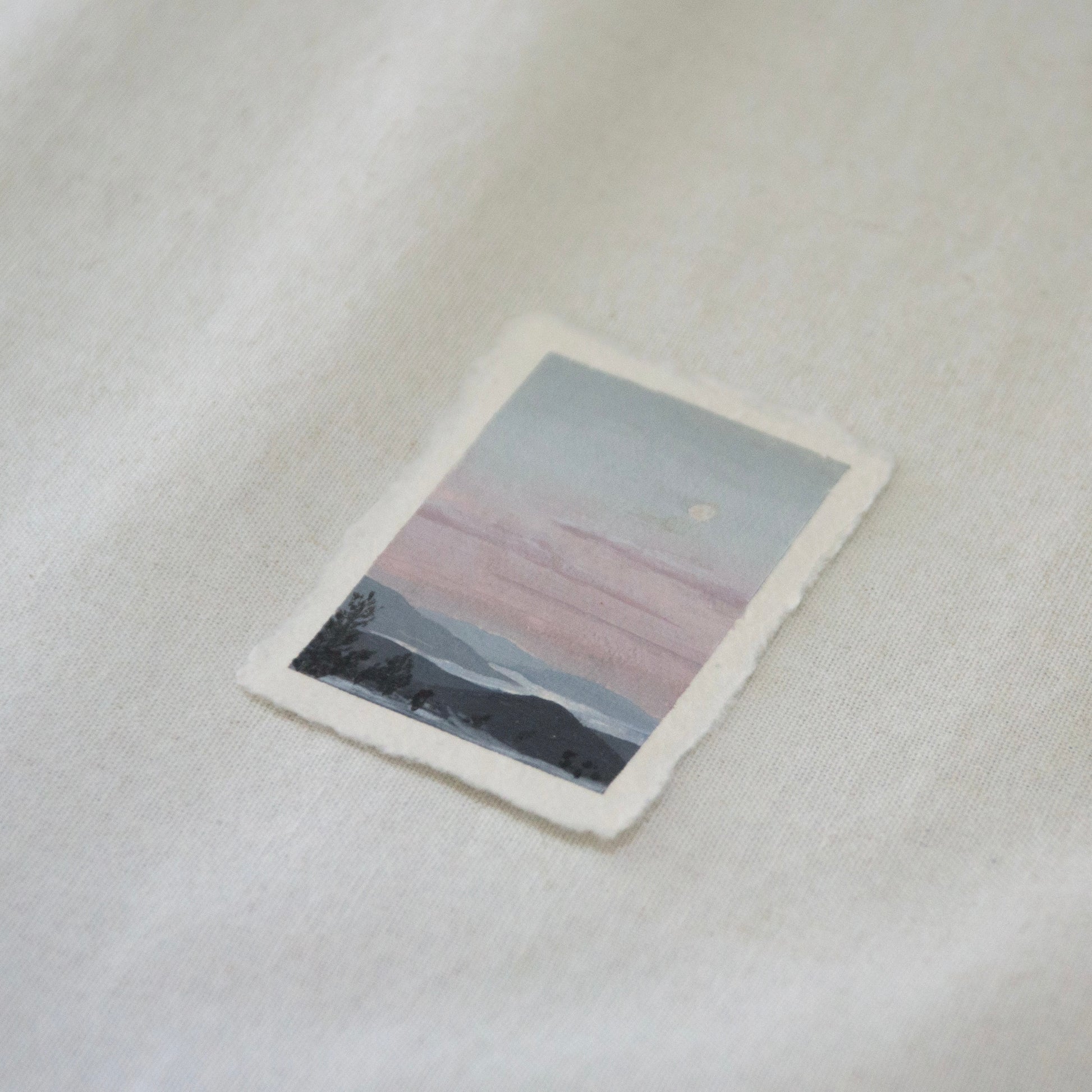 Side profile of overlook at Lassen Volcanic National Park of lakes and mountains during sunset painting on deckled edge 100% cotton rag paper