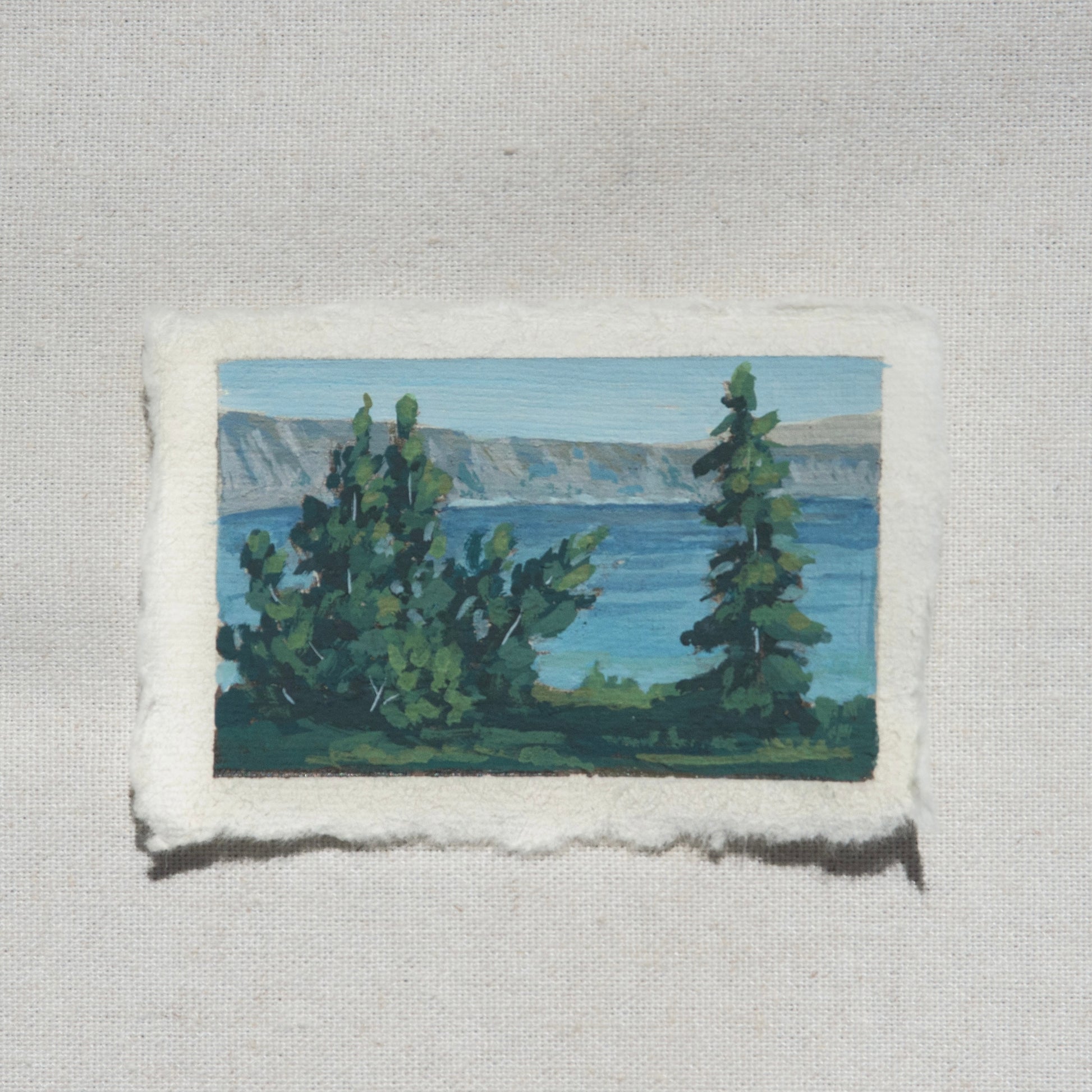 crater lake painting of lake, mountains, and emphasis on pine trees from Crater Lake National Park my Laura Van Moorleghem.