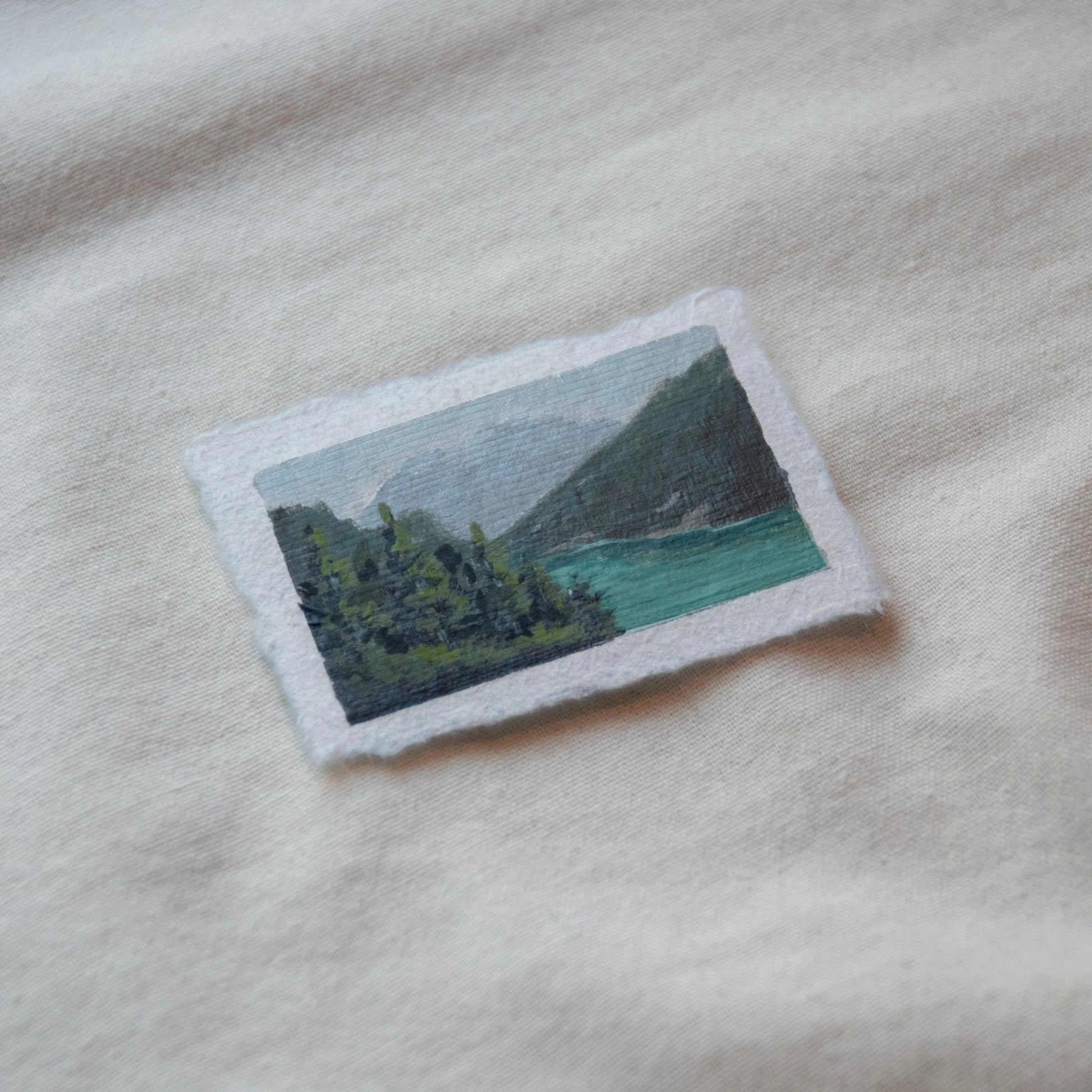 Side profile of diablo lake overlook, pine trees, and north cascade mountains painting on deckled edge 100% cotton rag paper