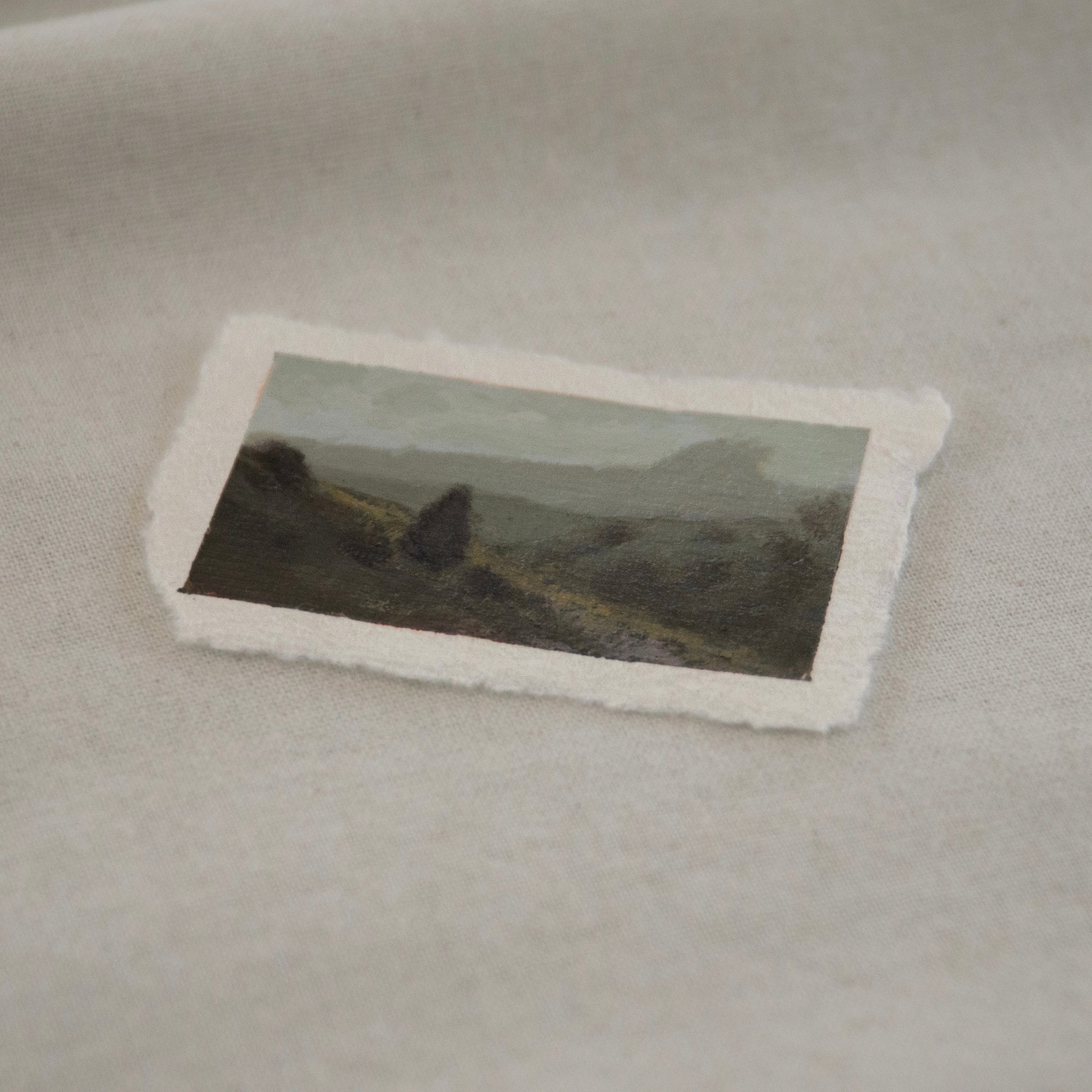 Side profile of pinnacles in a foggy distance with pinetree in foreground acrylic painting on deckled edge 100% cotton rag paper