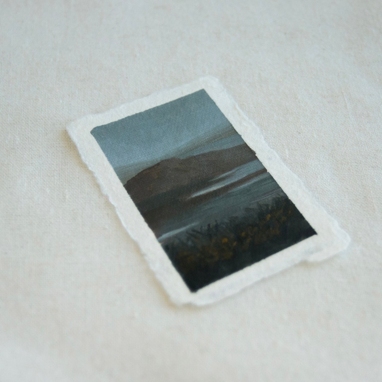 Side view of a small mini acrylic lanscape depicting a reflective lake and mountains in Point Reyes National Seashore 