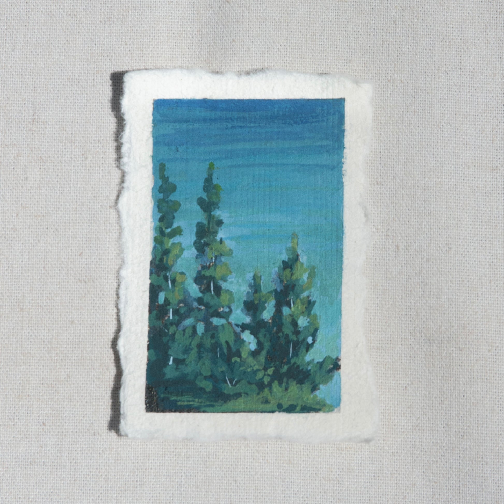 Mini gouache landscape of crater lake blues and pine trees overlooking crater lake by Laura Van Moorleghem from Crater Lake National Park